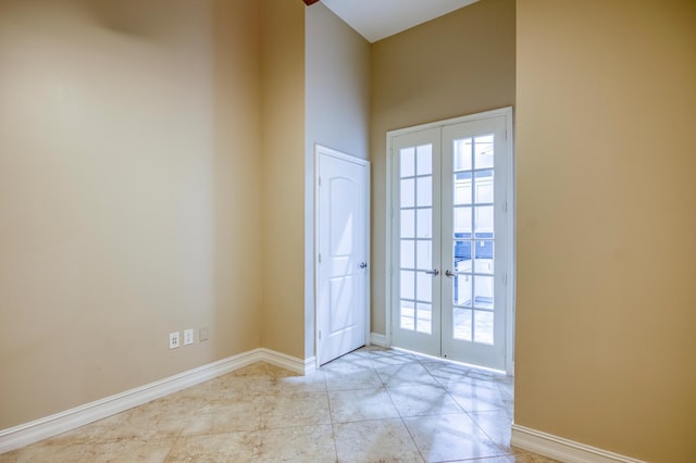 entryway with french doors, baseboards, and tile patterned floors