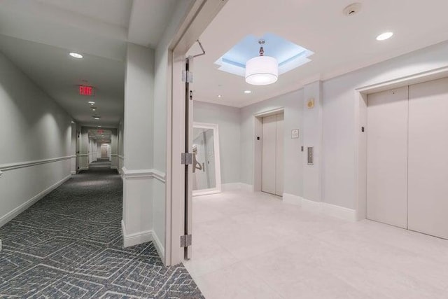 hallway with elevator, baseboards, and recessed lighting