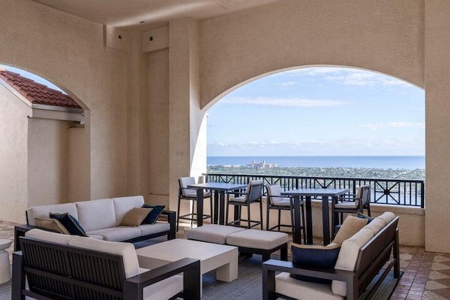 view of patio featuring outdoor lounge area, a water view, outdoor dining space, and a balcony