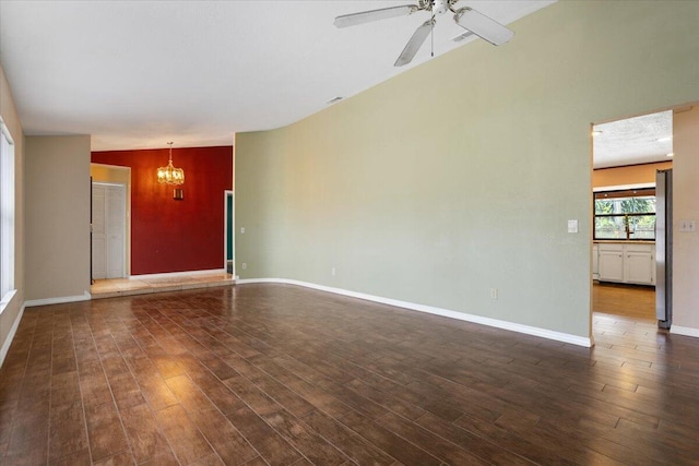 unfurnished living room featuring dark wood-type flooring, lofted ceiling, and ceiling fan with notable chandelier