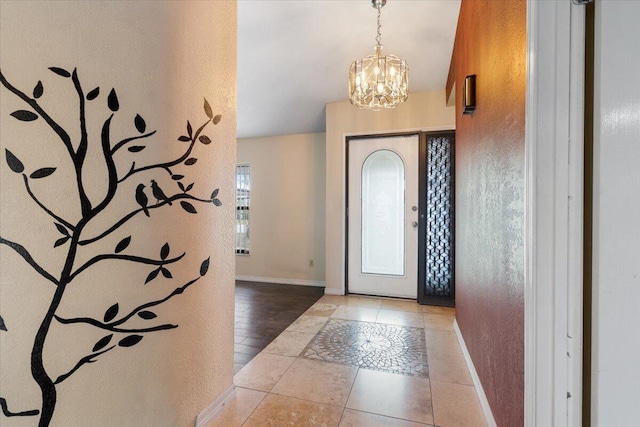 tiled entryway with a notable chandelier