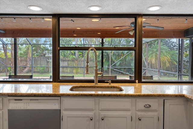 kitchen with white cabinetry, sink, light stone counters, and dishwasher