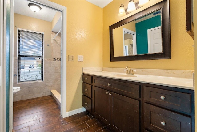 bathroom featuring vanity, a shower, and toilet