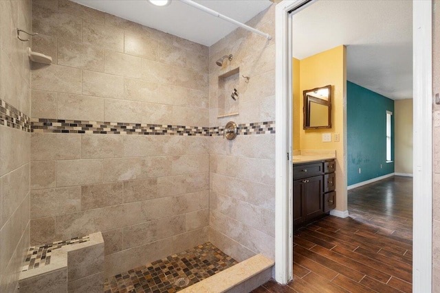 bathroom with vanity and a tile shower