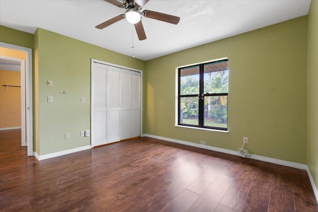 unfurnished bedroom featuring dark hardwood / wood-style floors, ceiling fan, and a closet