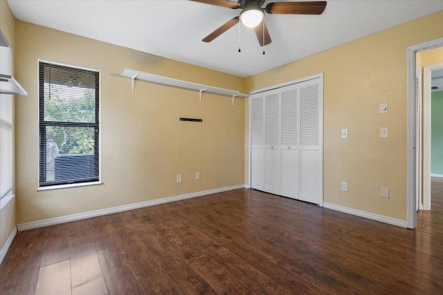 unfurnished bedroom featuring dark hardwood / wood-style flooring, ceiling fan, and a closet