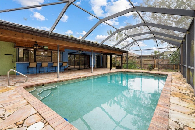 view of pool featuring a bar, a lanai, a patio area, and ceiling fan