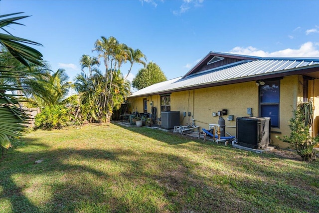 exterior space with central AC unit and a yard