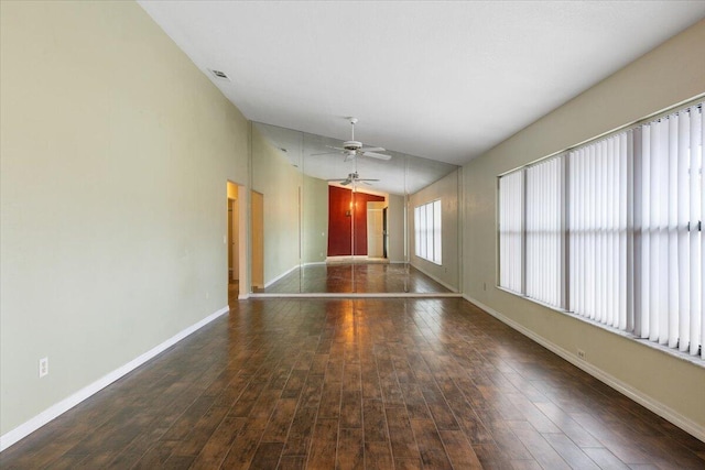 empty room with lofted ceiling, dark wood-type flooring, and ceiling fan