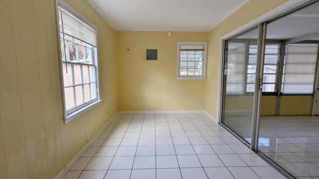 unfurnished room featuring wood walls and light tile patterned floors