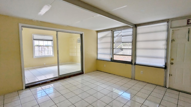 doorway to outside with light tile patterned flooring