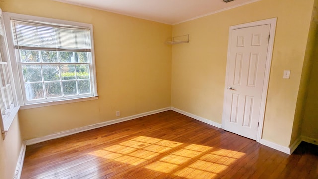 spare room with hardwood / wood-style floors and ornamental molding