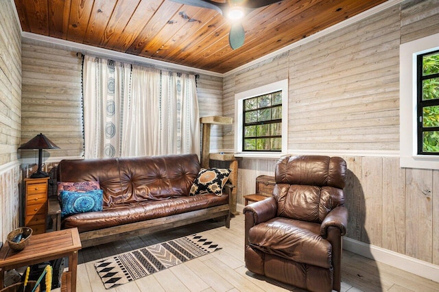 sitting room with wooden walls, wood ceiling, hardwood / wood-style floors, and a wealth of natural light