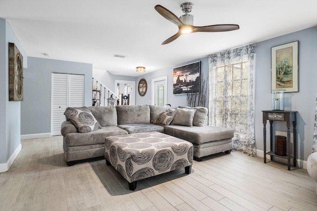 living room featuring light hardwood / wood-style flooring and ceiling fan