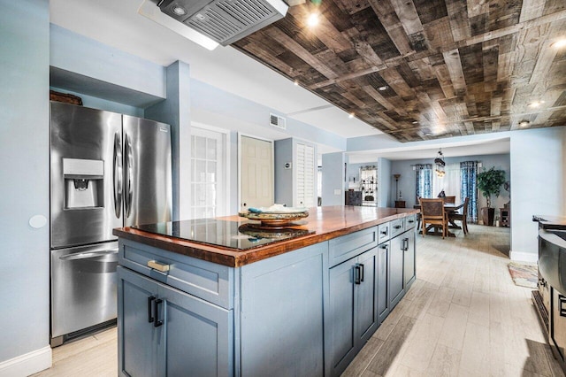 kitchen with wooden counters, stainless steel fridge, a center island, light hardwood / wood-style floors, and wooden ceiling