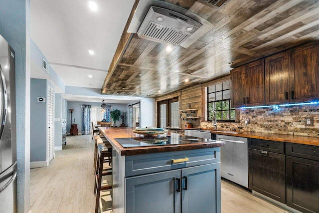 kitchen with butcher block countertops, wood ceiling, light hardwood / wood-style flooring, dishwasher, and a center island