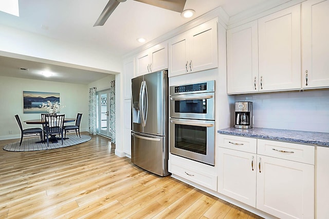 kitchen featuring white cabinets, appliances with stainless steel finishes, and light hardwood / wood-style flooring