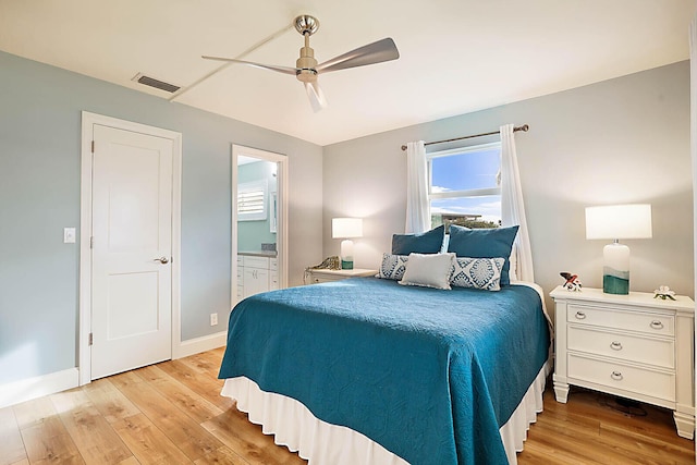 bedroom with connected bathroom, ceiling fan, and light hardwood / wood-style flooring