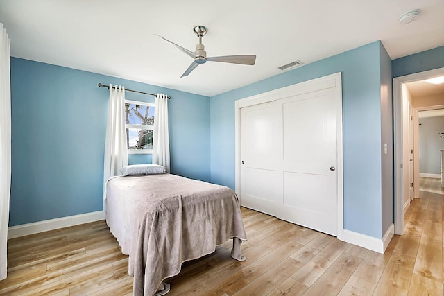 bedroom with ceiling fan, a closet, and light hardwood / wood-style floors