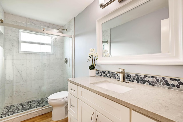 bathroom with backsplash, wood-type flooring, an enclosed shower, toilet, and vanity