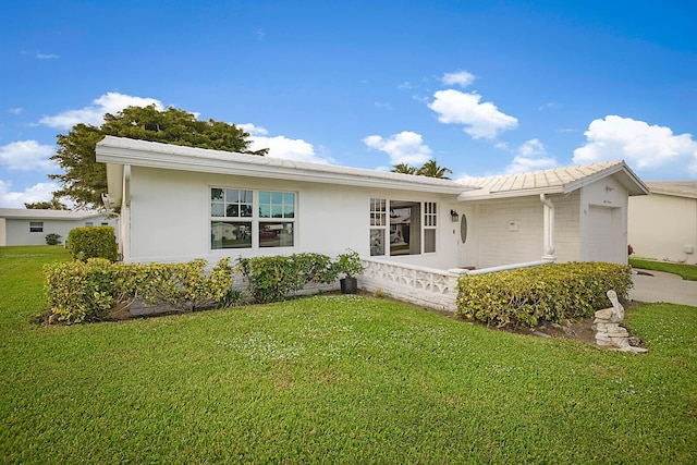 ranch-style home with a garage and a front lawn