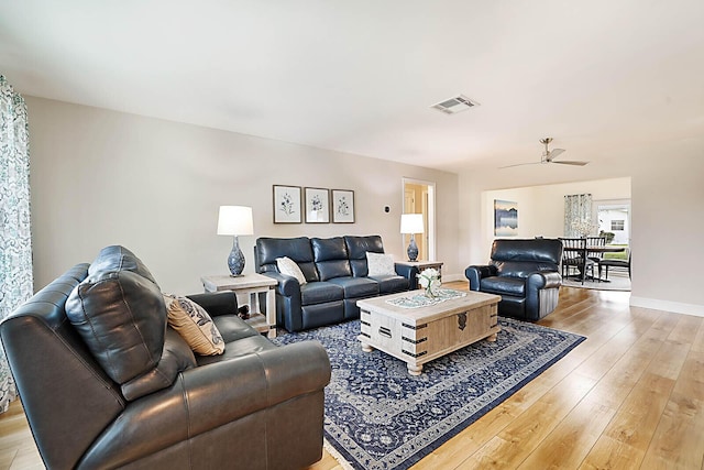 living room featuring light hardwood / wood-style floors and ceiling fan