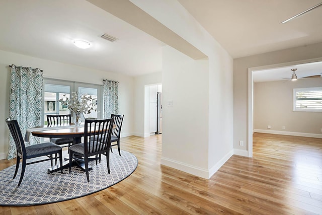 dining space with ceiling fan and light hardwood / wood-style flooring