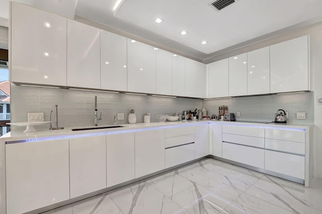 kitchen with white cabinets, tasteful backsplash, and sink