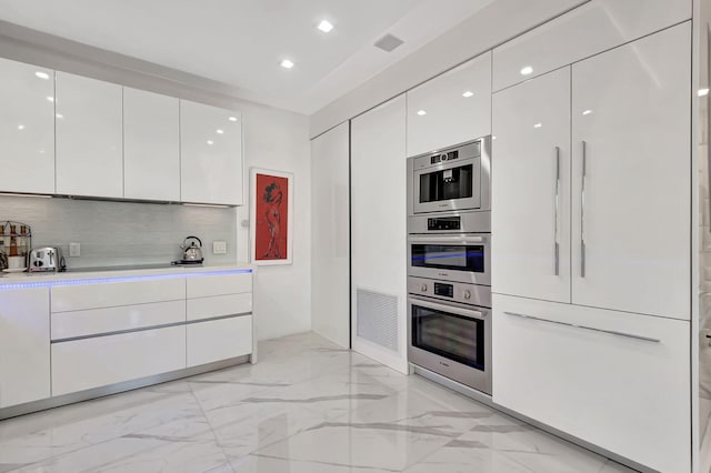 kitchen featuring white cabinetry, appliances with stainless steel finishes, and tasteful backsplash