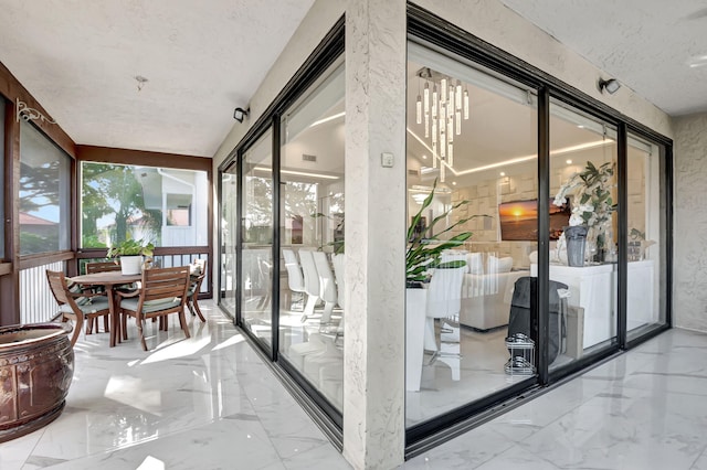 sunroom / solarium with an inviting chandelier