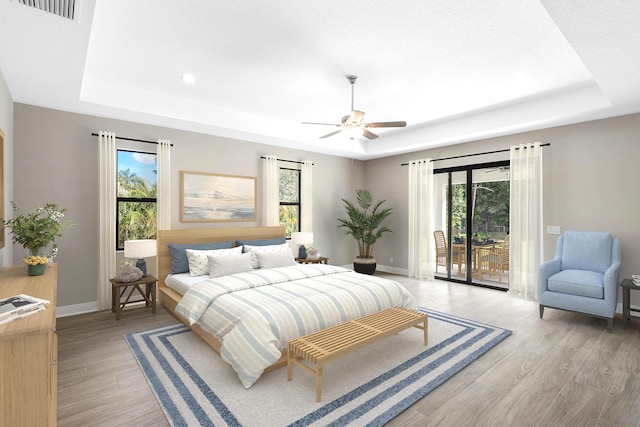 bedroom featuring access to exterior, ceiling fan, and a raised ceiling