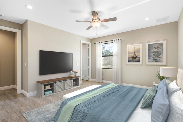 bedroom with ceiling fan, light hardwood / wood-style floors, and ensuite bath