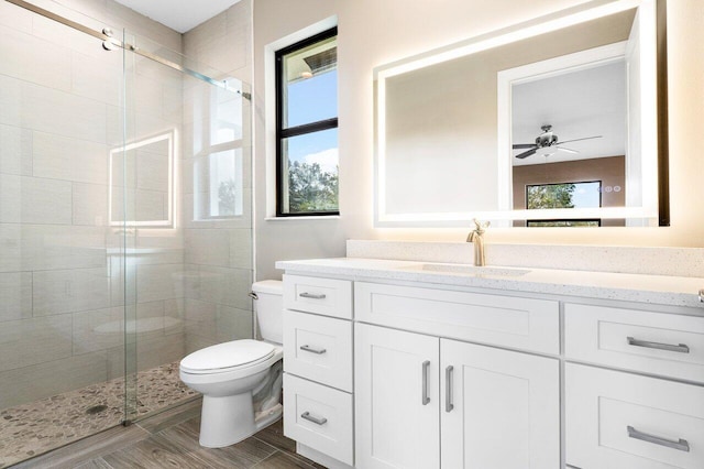 bathroom featuring an enclosed shower, vanity, toilet, and ceiling fan