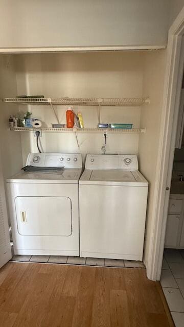 clothes washing area with wood-type flooring and washing machine and clothes dryer