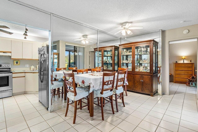 tiled dining room featuring ceiling fan and a textured ceiling