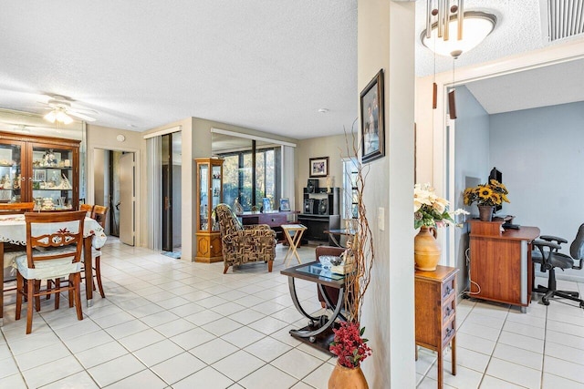 dining room featuring ceiling fan, light tile patterned flooring, and a textured ceiling