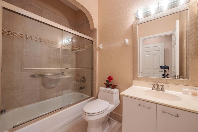 full bathroom featuring combined bath / shower with glass door, toilet, and vanity