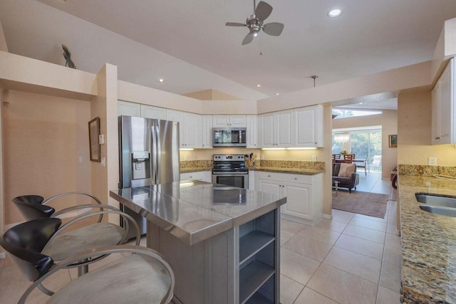 kitchen with white cabinets, ceiling fan, light tile patterned flooring, and stainless steel appliances