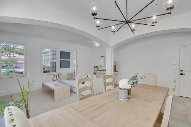 dining area featuring decorative columns and an inviting chandelier