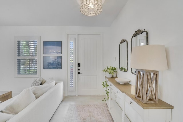 entryway with light tile patterned flooring and vaulted ceiling