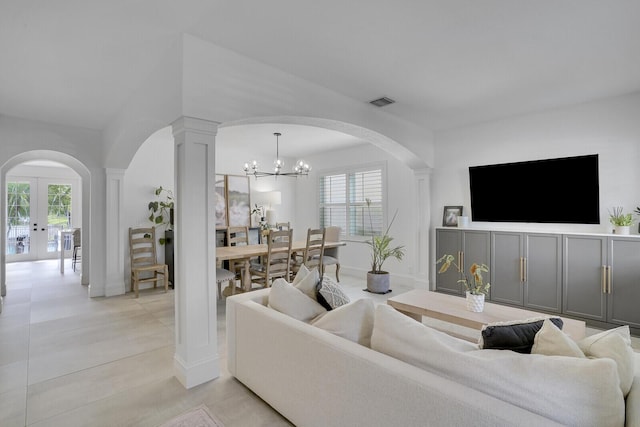 living room featuring french doors, light tile patterned floors, and a notable chandelier