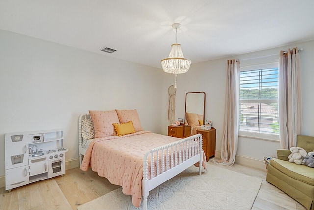 bedroom with a chandelier and hardwood / wood-style flooring