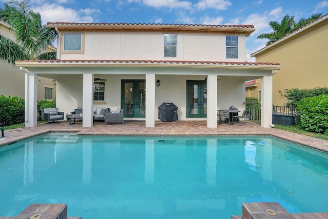 back of property featuring an outdoor living space, french doors, and a patio