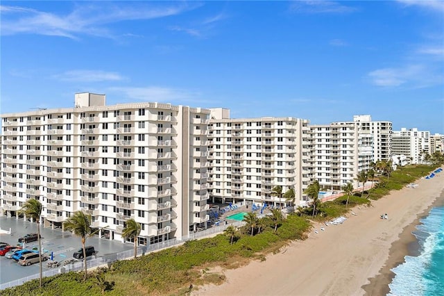 view of building exterior with a beach view and a water view