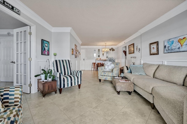 living room featuring light tile patterned floors, a textured ceiling, crown molding, and a notable chandelier