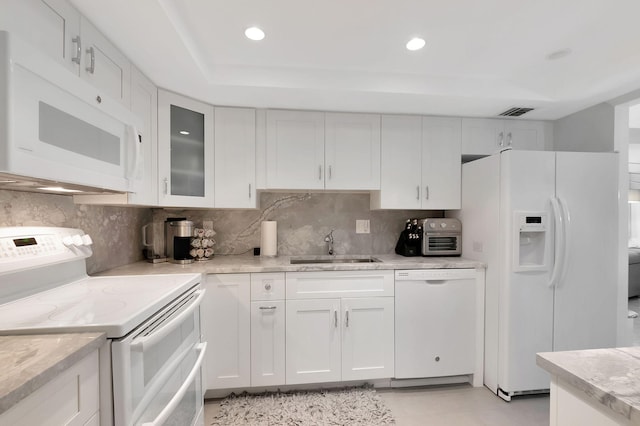 kitchen with decorative backsplash, white appliances, white cabinetry, and sink