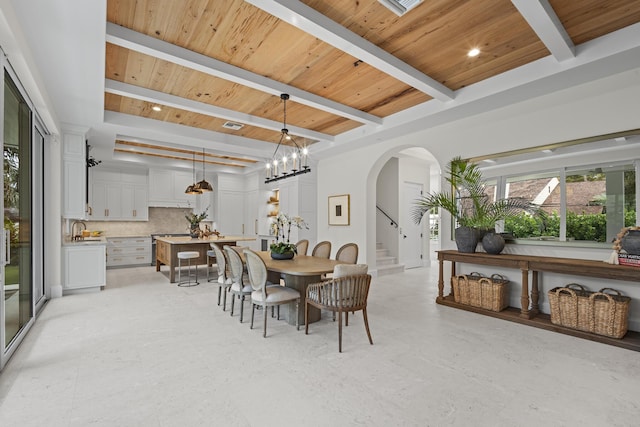 dining area with beam ceiling, wood ceiling, and a chandelier