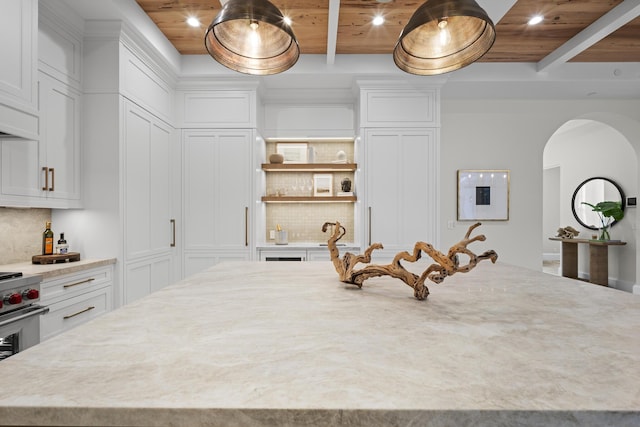 kitchen featuring tasteful backsplash, white cabinetry, a kitchen island, and wooden ceiling