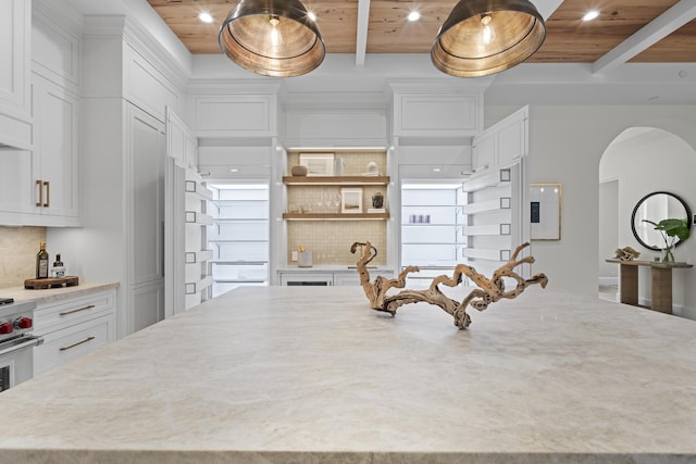 kitchen with white cabinets, backsplash, a kitchen island, and wooden ceiling