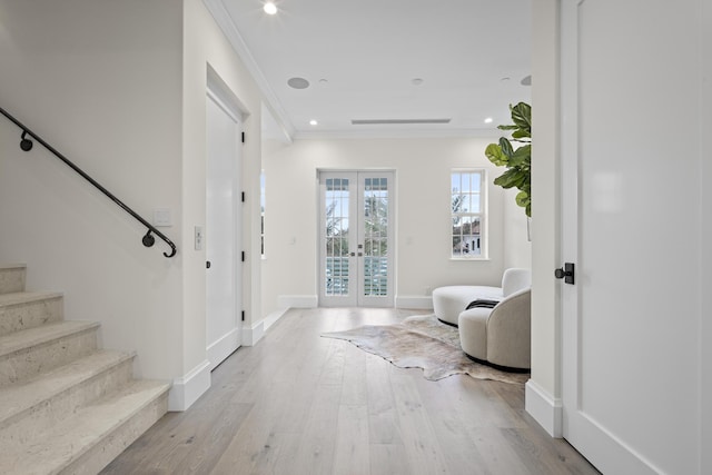 entryway featuring light hardwood / wood-style floors, ornamental molding, and french doors